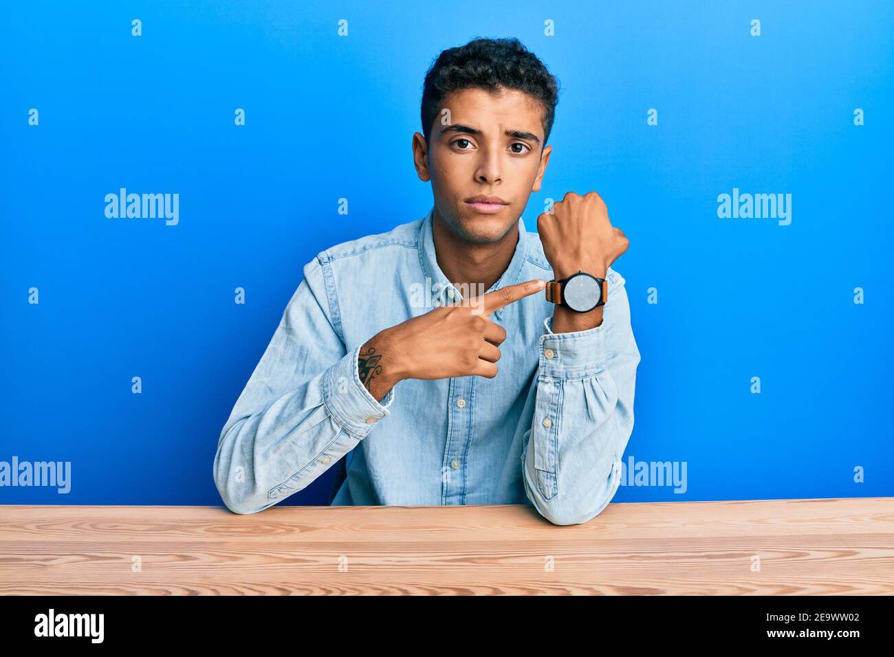Young handsome african american man wearing casual clothes sitting on ...