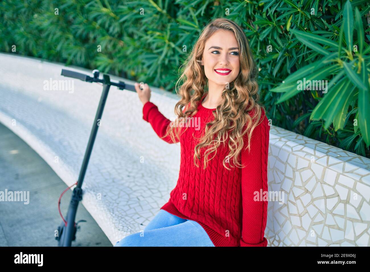 Young blonde girl smiling happy sitting on the bench at the park Stock ...