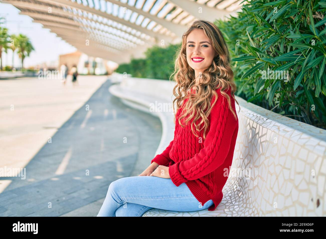 Young blonde girl smiling happy sitting on the bench at the park Stock ...
