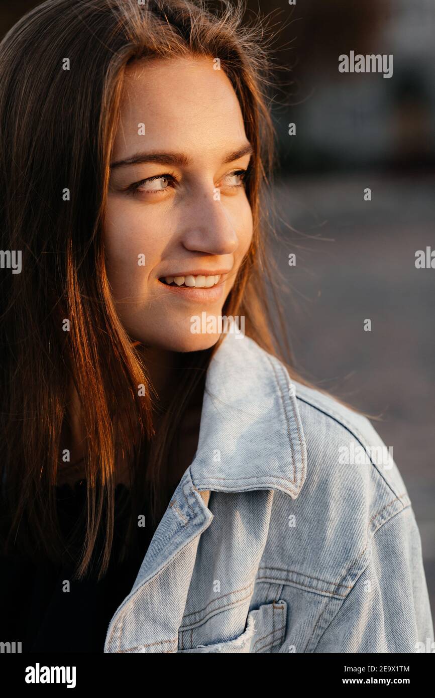 Charming girl in jeans jacket looking to the side and smiling. Girl portrait Stock Photo