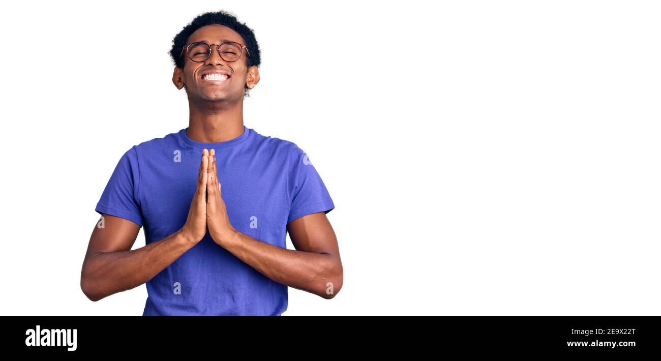 African handsome man wearing casual clothes and glasses begging and praying with hands together with hope expression on face very emotional and worrie Stock Photo