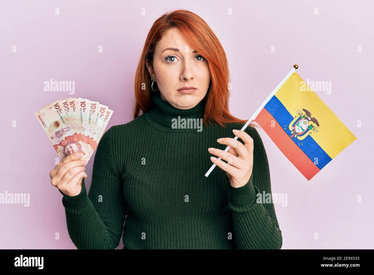 Beautiful redhead woman holding colombia flag and 10 colombian pesos ...