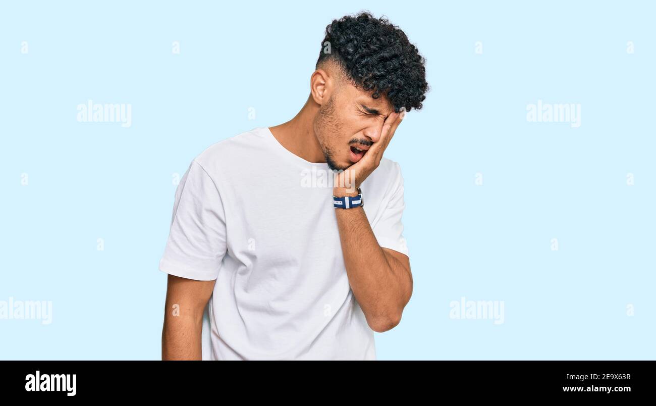 Young Arab Man Wearing Casual White T Shirt Yawning Tired Covering Half Face Eye And Mouth With Hand Face Hurts In Pain Stock Photo Alamy