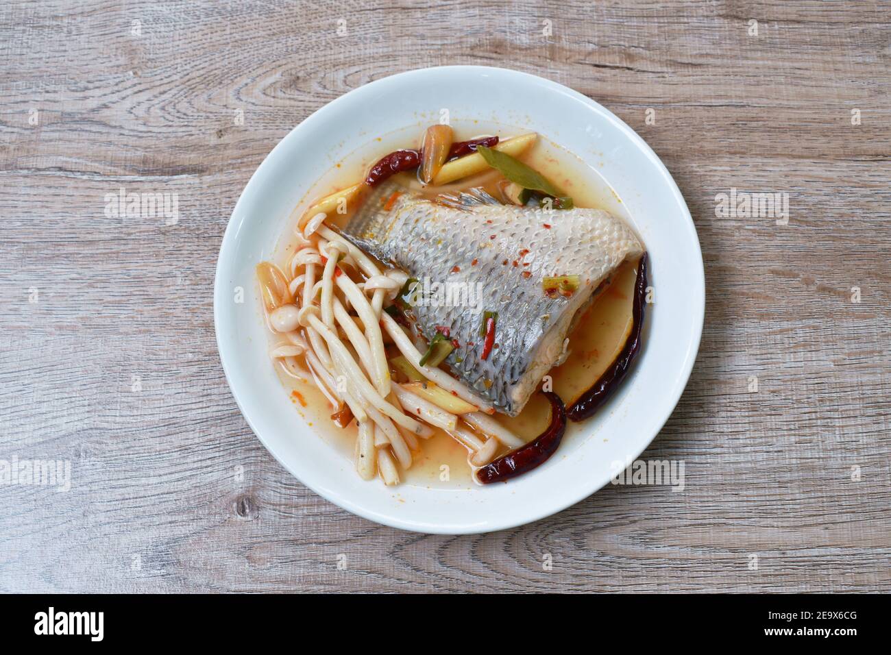 spicy boiled Tilapia or mango fish tail with shimaji mushroon in tom yum soup on plate Stock