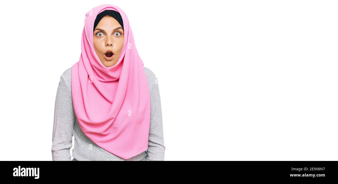 Young caucasian woman wearing traditional islamic hijab scarf scared