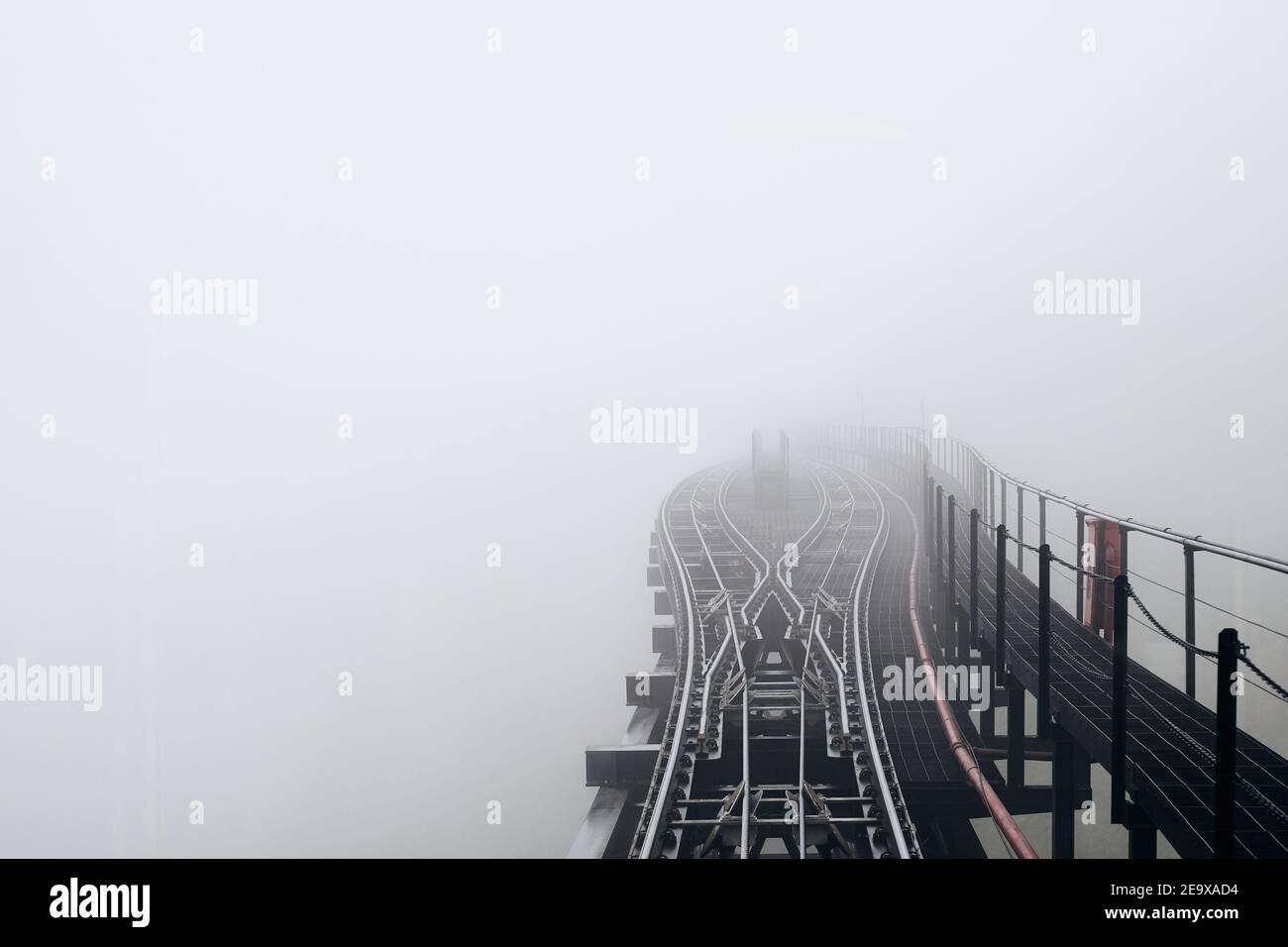 Junction in thick fog. View from train of elevated mountain railway from Sa Pa to cable car station to Fansipan, Vietnam Stock Photo