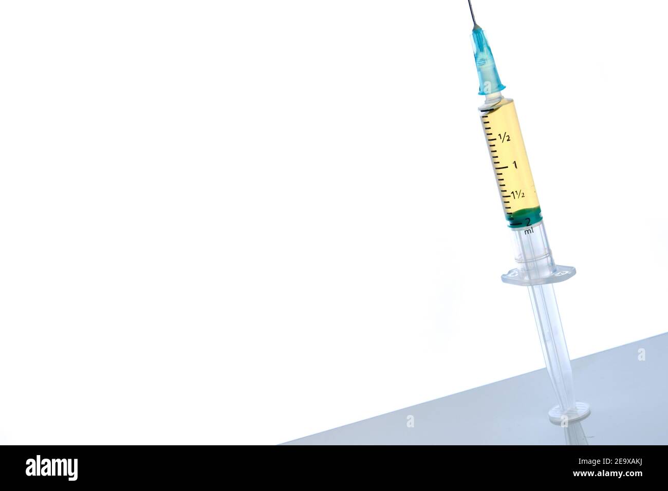 Vaccine dose in syringe on mirror surface, white background, selective focus Stock Photo