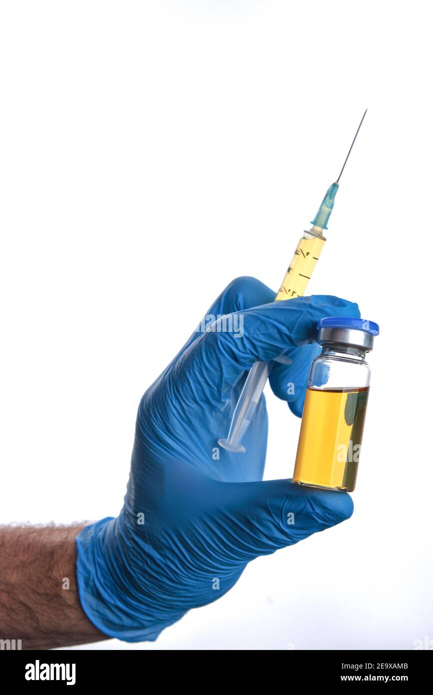 Male doctor hand in blue glove holds syringe and vial bottle with covid-19 vaccine multiple injections dose. Coronavirus cure, flu medicine treatment Stock Photo
