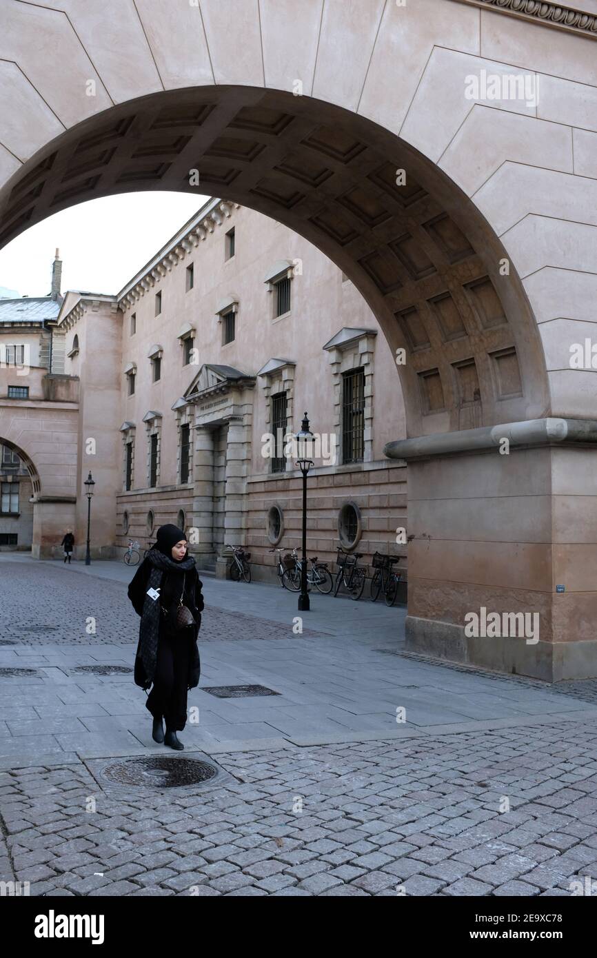 Copenhagen - January 2019: A lady walking through the Copenhagen Courthouse alleyway Stock Photo