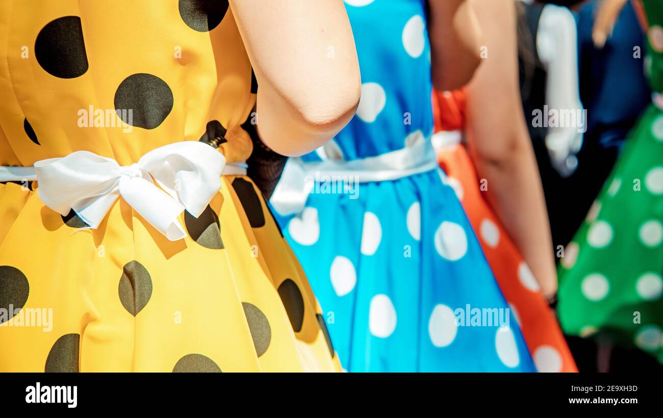 Group of teen girls in multicolored dresses with polka dots. Retro fashion style. Stock Photo
