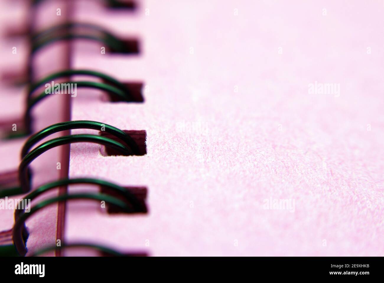 Spiral binder, pink notebook, foreground, desk background Stock Photo