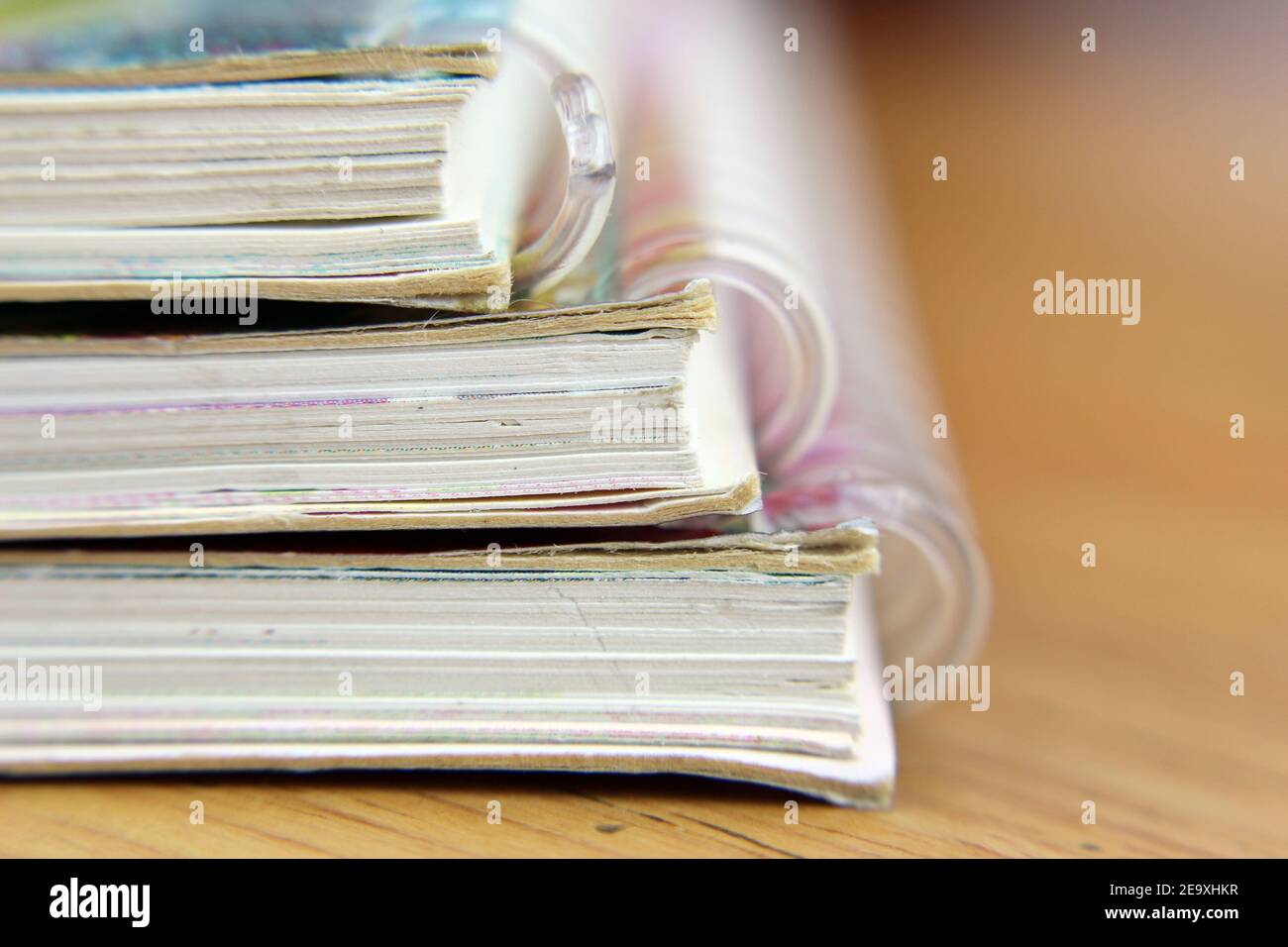 Spiral binder, three notebooks in the foreground, desk background Stock Photo