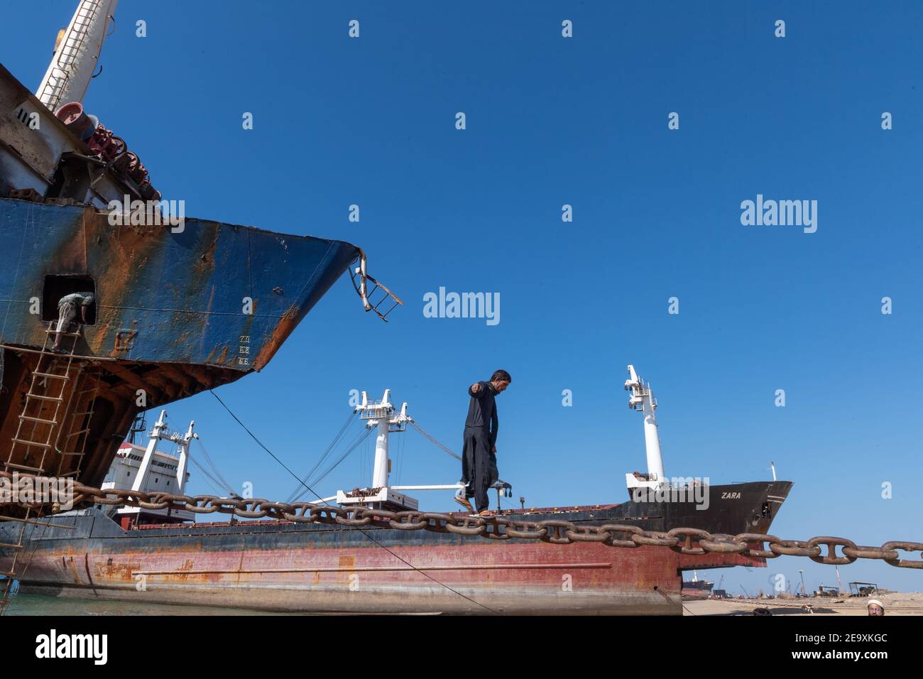 Worker breaking up ship at Gadani ship-breaking yard, located across a 10 km long beachfront, Balochistan, Pakistan. Stock Photo