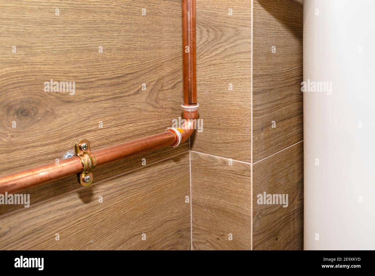 Copper pipes for natural gas installations, attached to a wall in a boiler room lined with