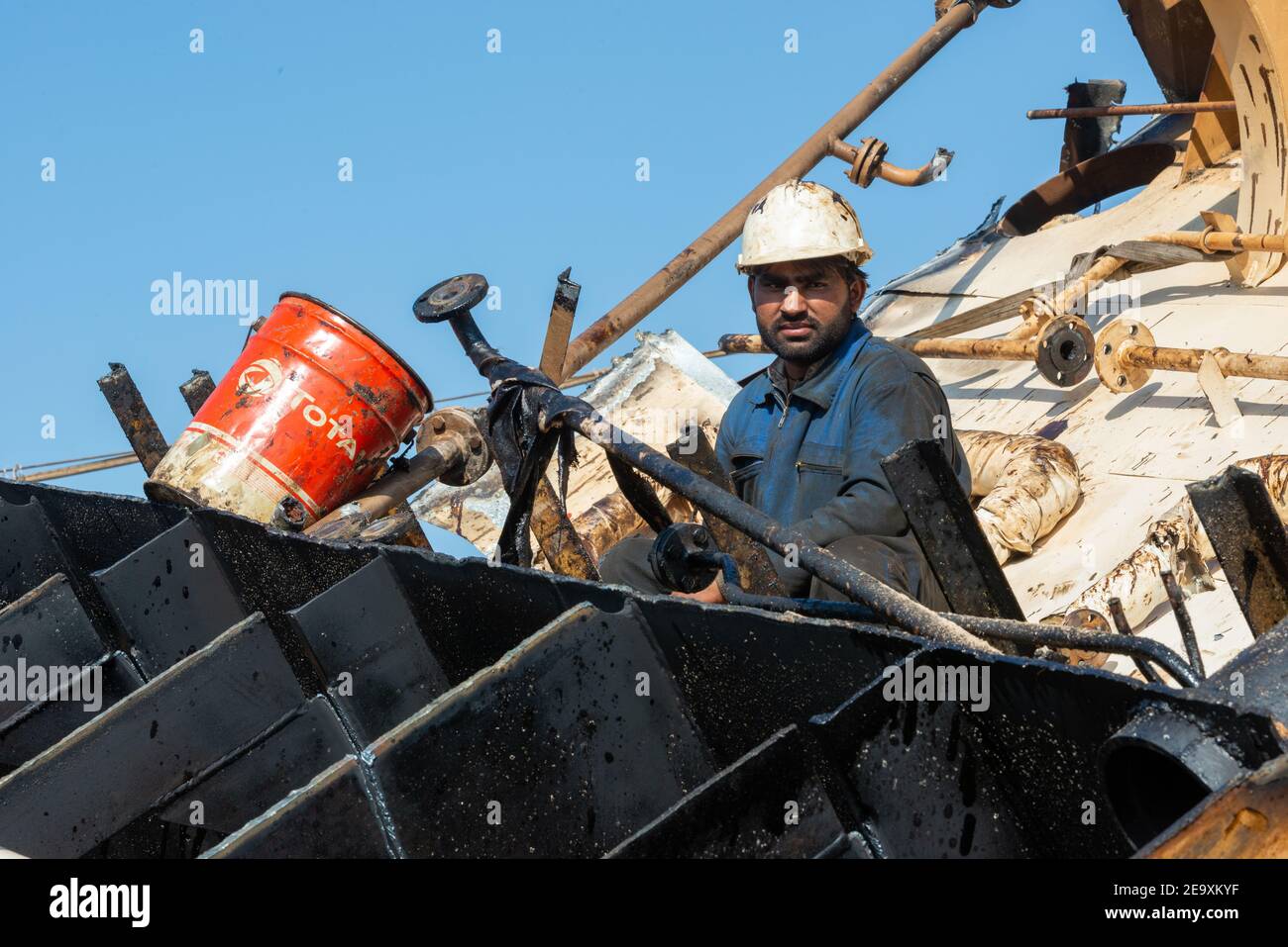 Worker breaking up ship at Gadani ship-breaking yard, located across a 10 km long beachfront, Balochistan, Pakistan. Stock Photo