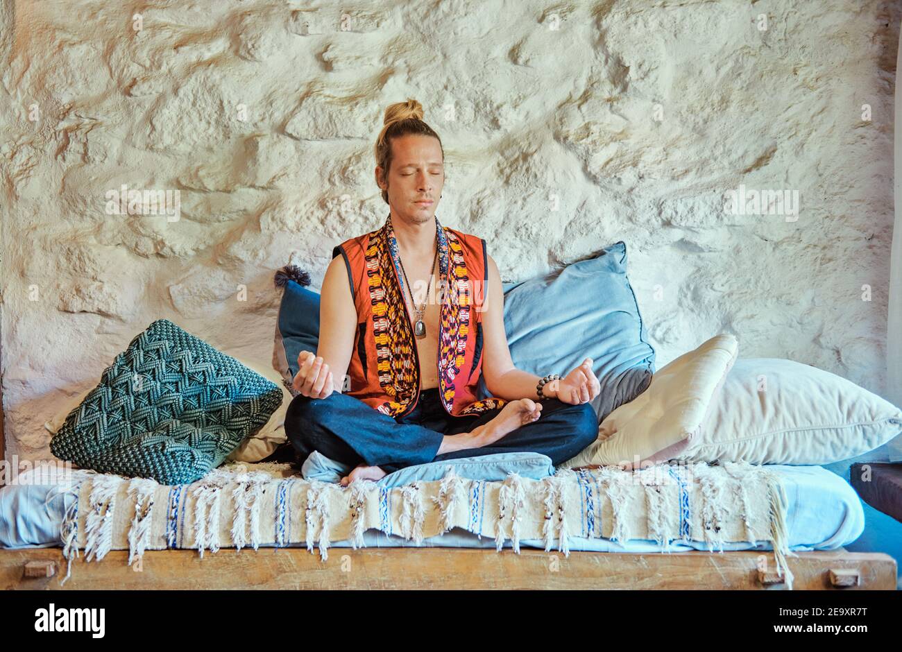 Blond man practicing meditation with closed eyes at home Stock Photo