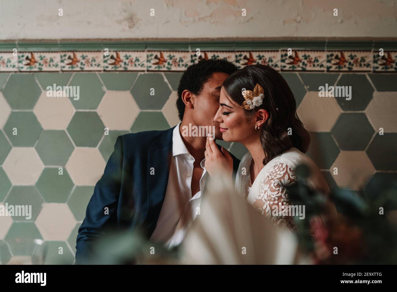 Anonymous Ethnic Man In Suit Whispering In Ear Of Content Beloved With Closed Eyes While Sitting At Restaurant Table On Wedding Day Stock Photo Alamy