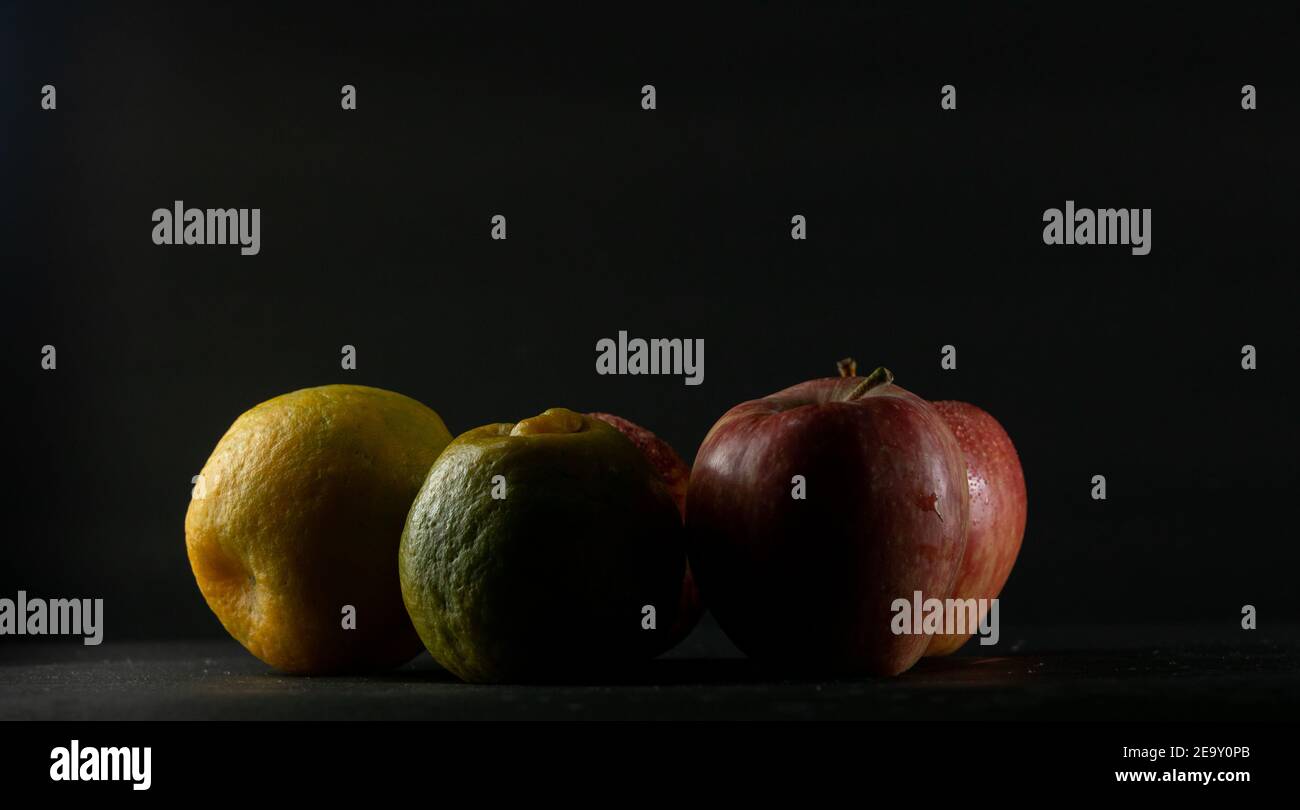 Apples and oranges in black background Stock Photo