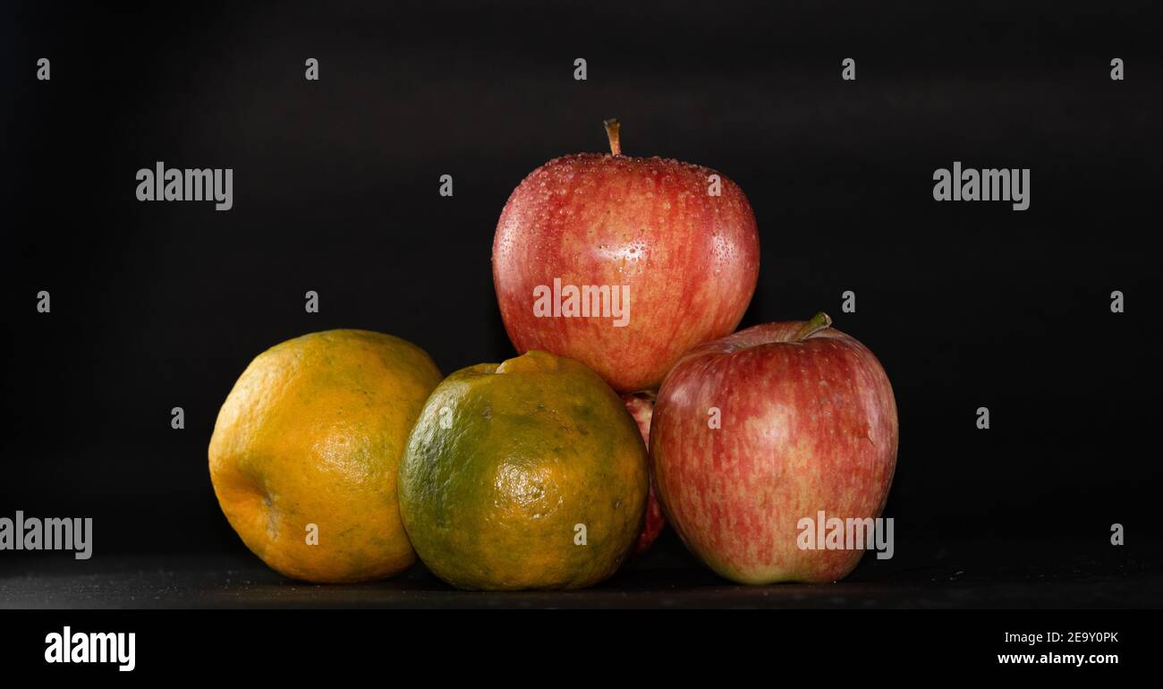 Apples and oranges arranged in black background Stock Photo