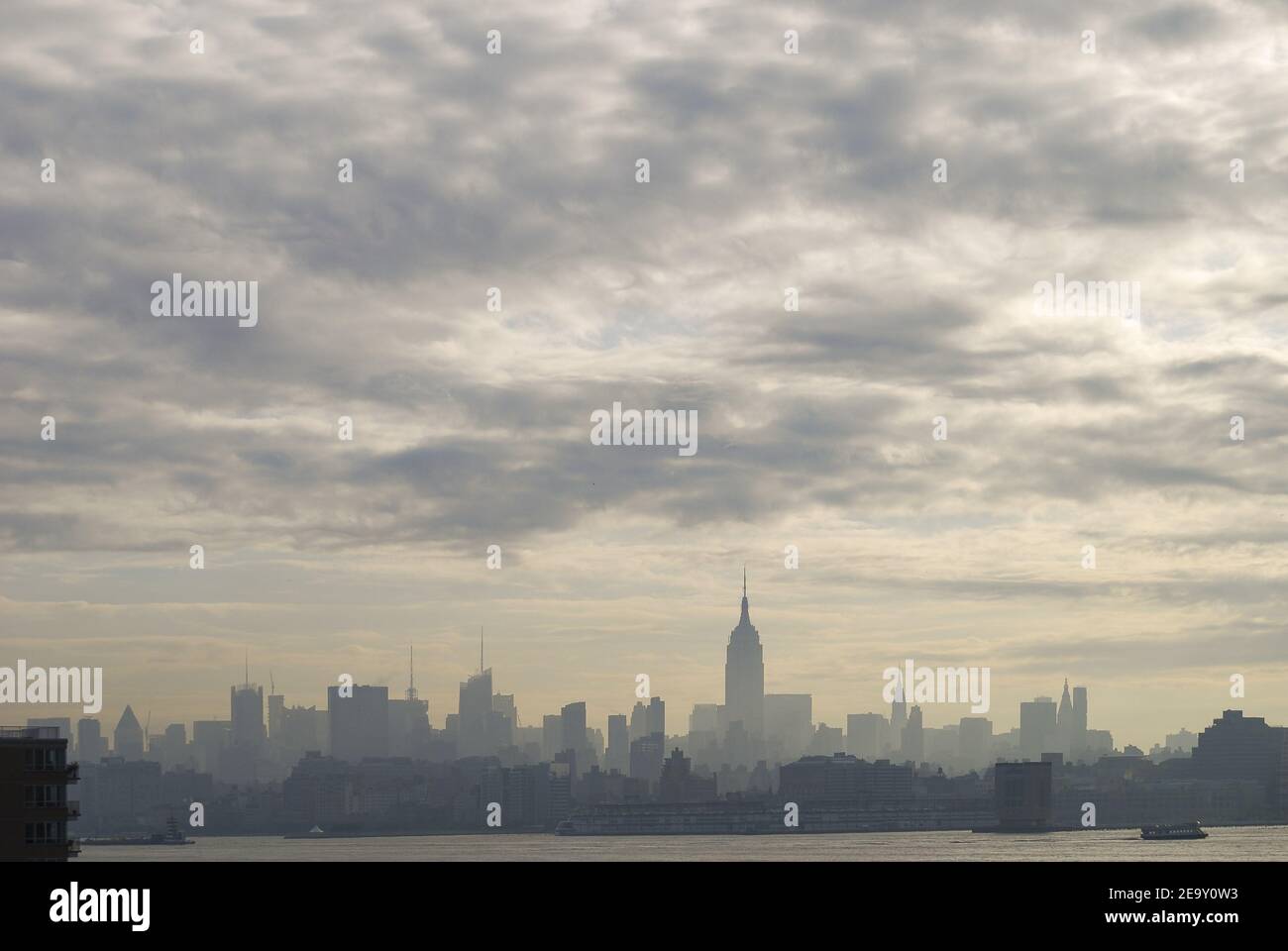 Skyline of New York City under a cloudy sky and sunlight in the USA ...