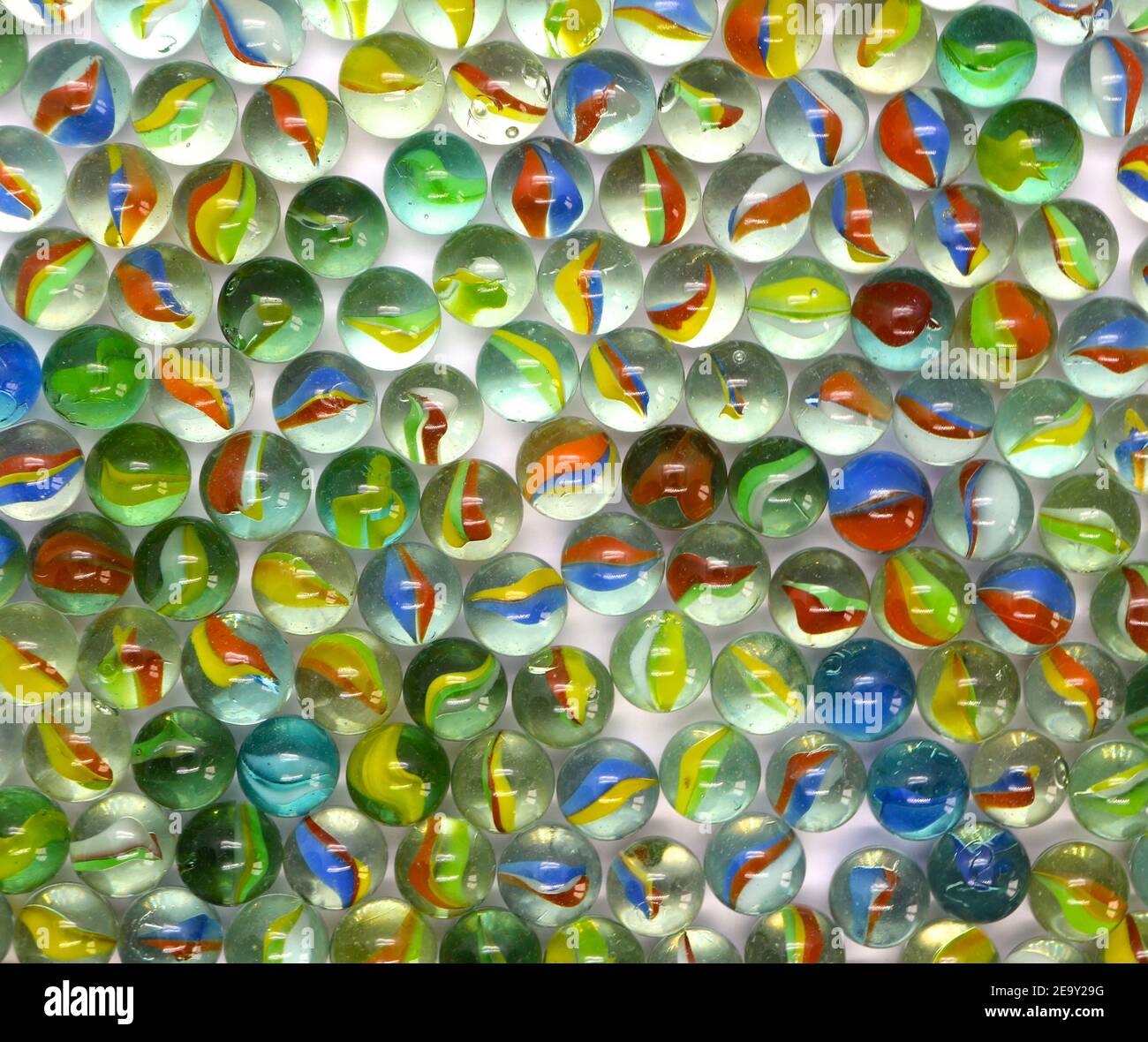 Photo of Dozens of colourful glass marbles from above Stock Photo