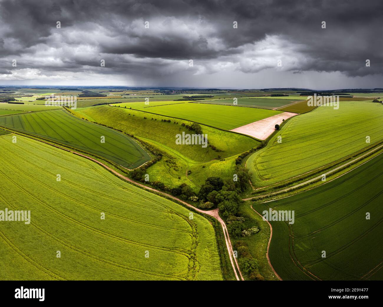 Aerial photo of lush green fields and dry chalk valley, Holm Dale, in Yorkshire Wolds with storm approaching Stock Photo
