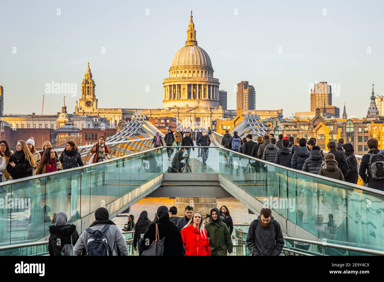 Crowds of people crossing the London Millennium Footbridge with Saint Paul's Cathedral in the background Stock Photo