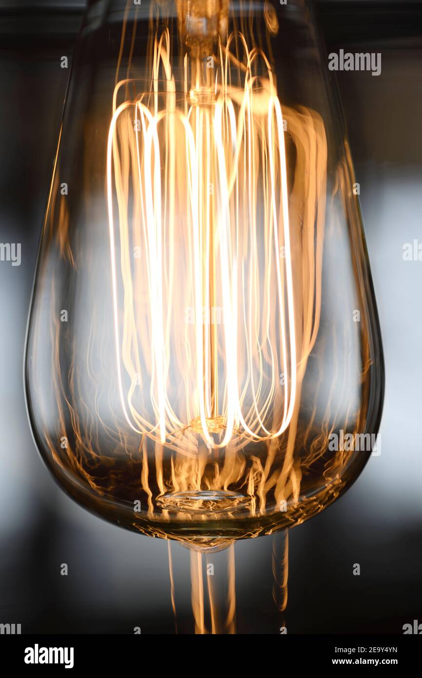 100W Edison light bulb filaments in glass lighting fixture Stock Photo