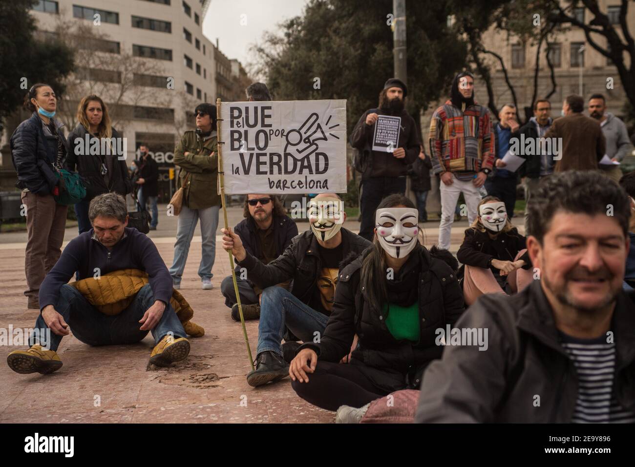 A protester wearing a mask of the British graphic novel, V for Vendetta and a banner that reads, the people for the truth, Barcelona, during the demonstration.Policias por la Liberdad (police for freedom) have called for a denial demonstration where they have meditated, sung songs and asked for an end to the Covid-19 restrictions. Stock Photo