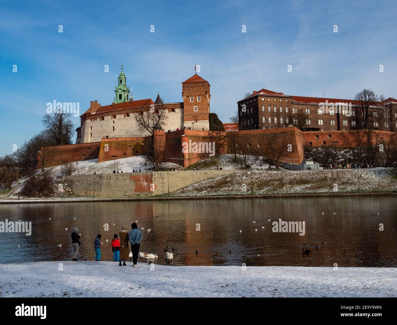 31/01/2021 - Poland/Cracow - view over Vistula River and Wawel Castle, the biggest attraction of Cracow. Winter time and people feeding swans. Stock Photo