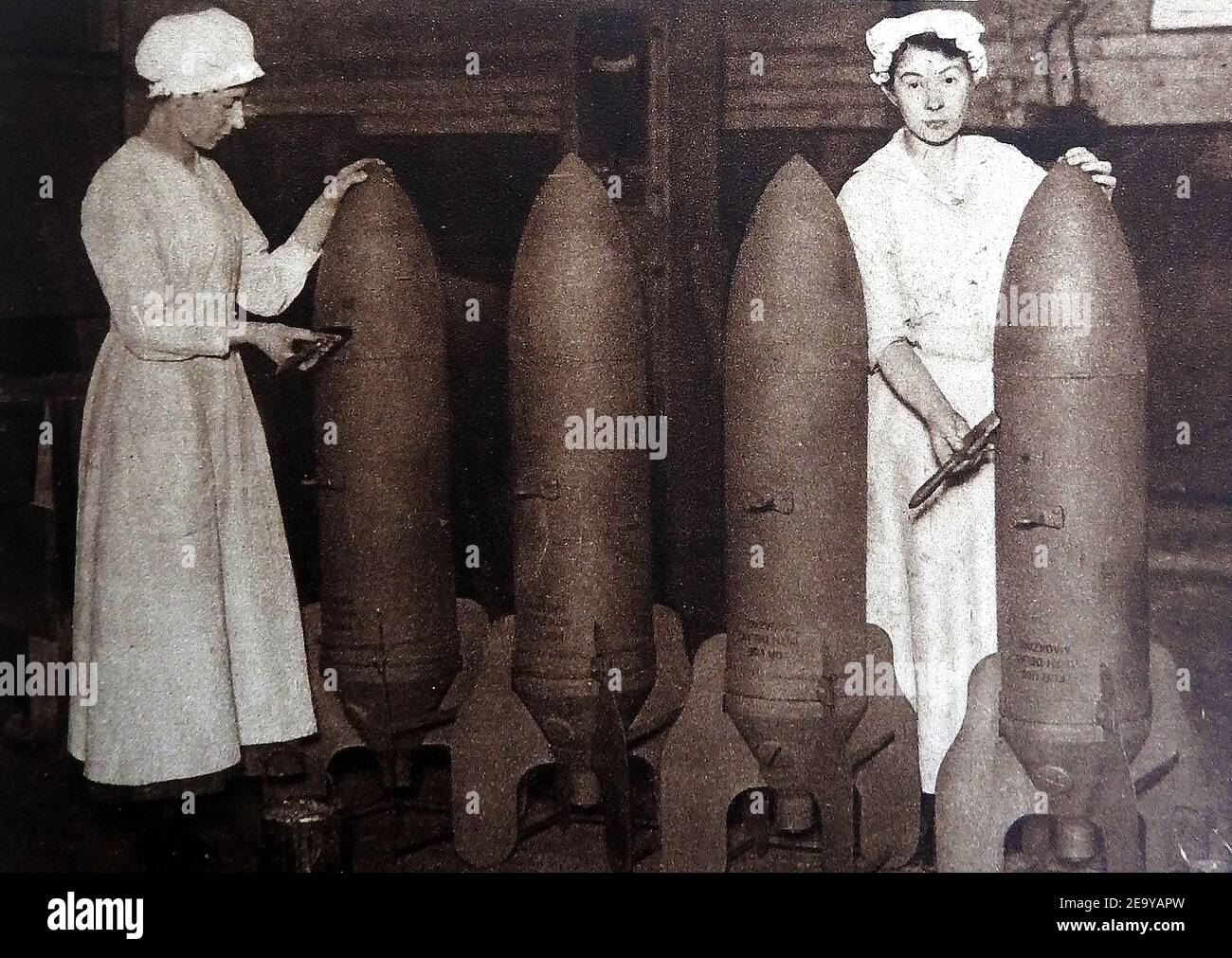 WVWI - Land Girls and women taking over the jobs of their menfolk in  Britain. A 1919  photo of British female munition workers putting a coat of paint on aerial bombs, one of the many tasks they learned whilst their menfolk were at war Stock Photo