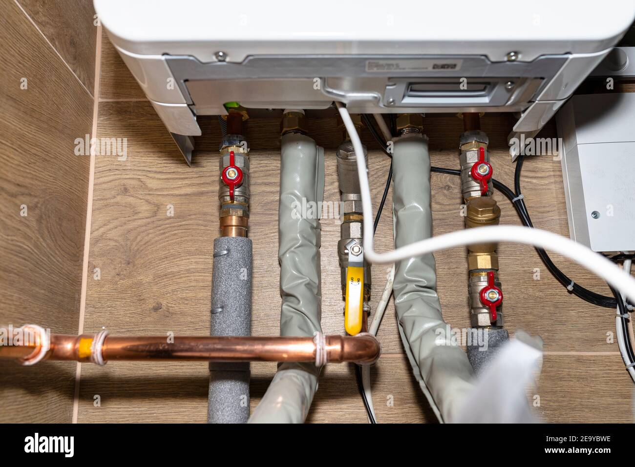 Natural gas valves and pipes in a modern home boiler room with ceramic ...