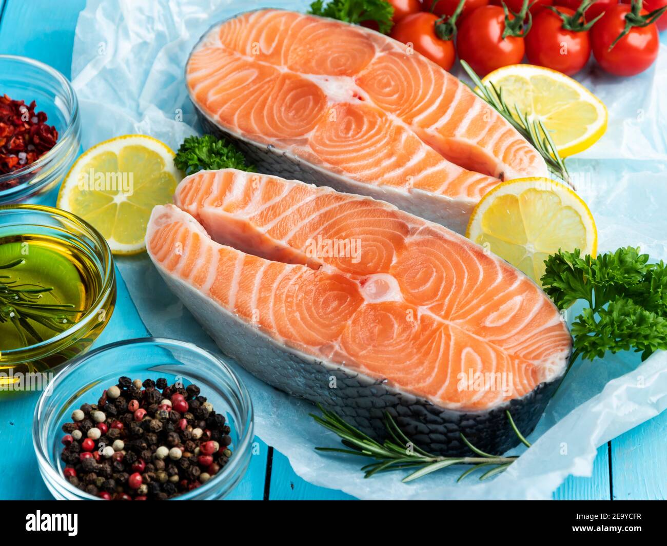 two raw fresh steak fish trout, salmon and spices on a blue wooden background Stock Photo