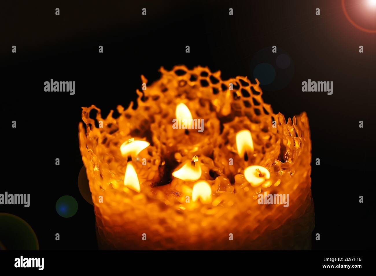 one large candle made of beeswax on a black background, top view of