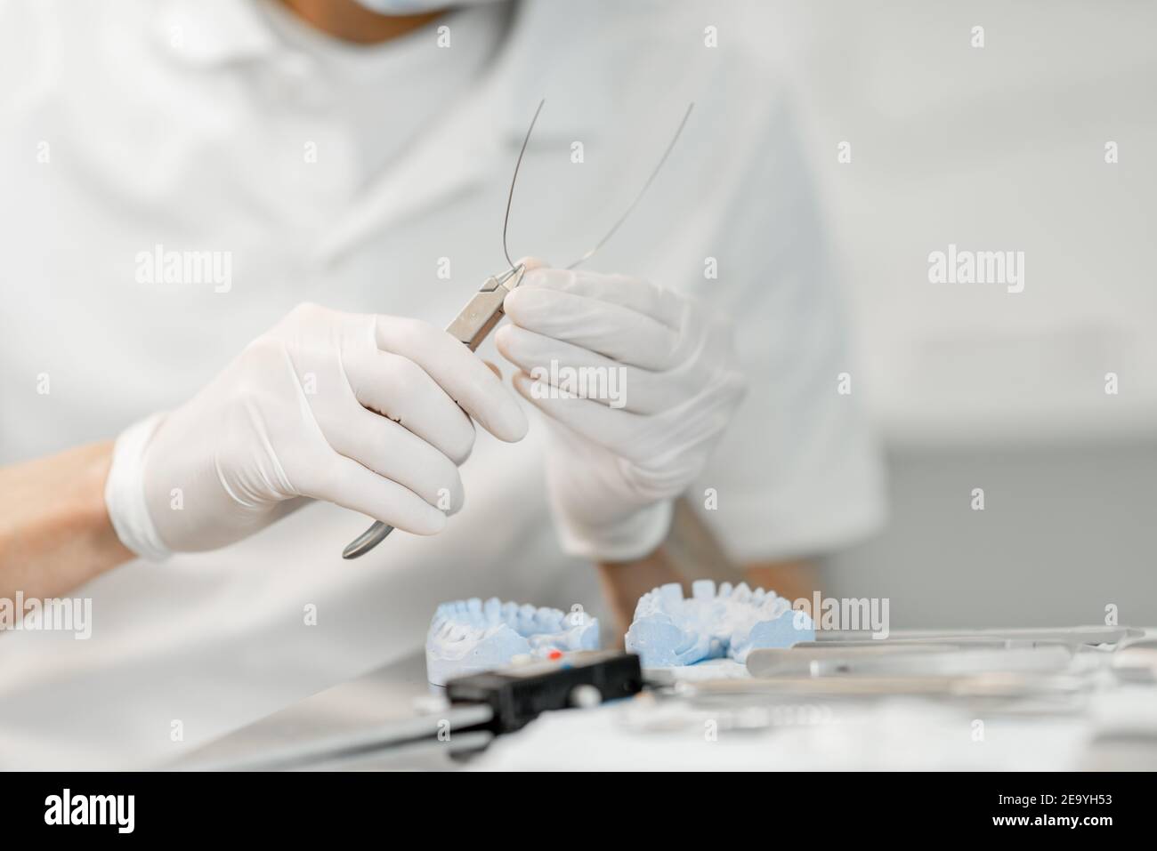 Dental technician working with a model of teeth and dental braces Stock ...