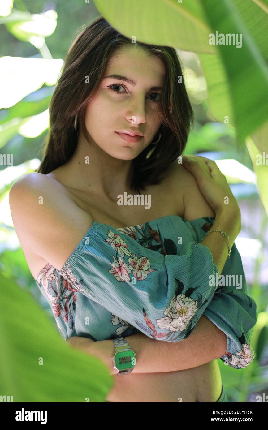 Vertical closeup shot of a beautiful young woman among vegetation Stock Photo