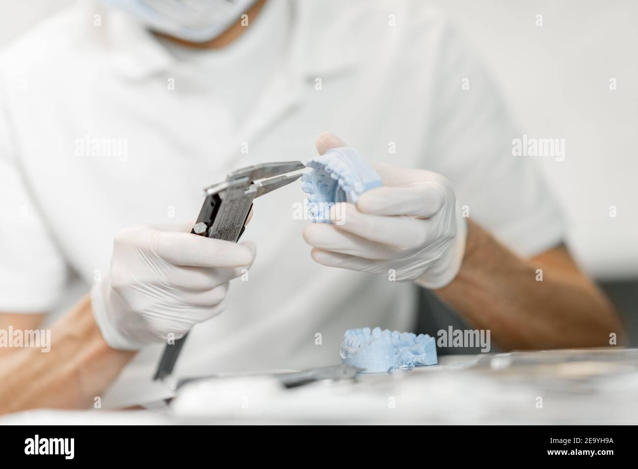 Dental technician working with a model of teeth and dental braces Stock ...