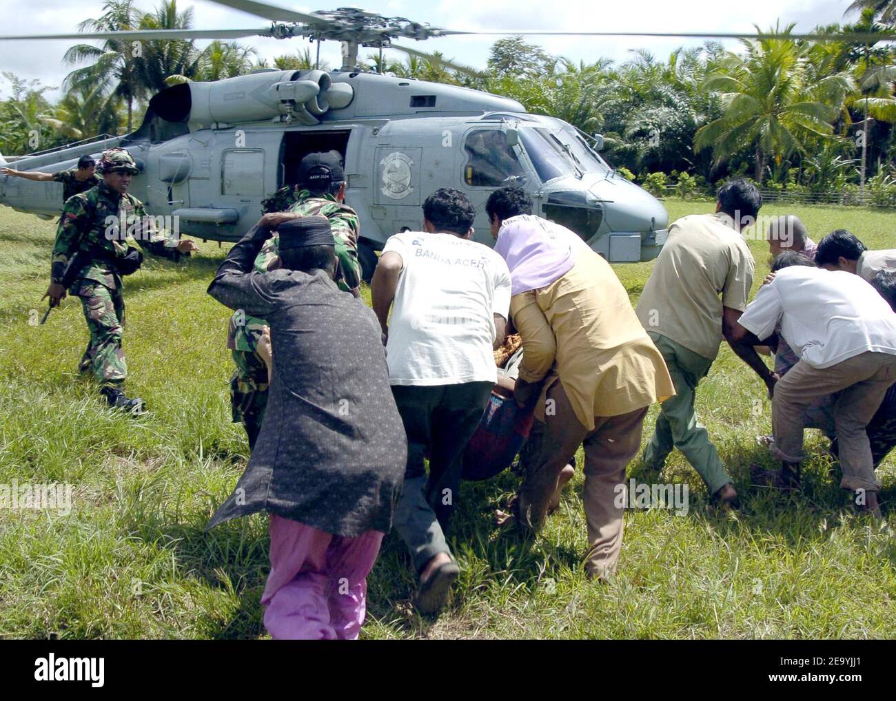 Indonesian civilians rush to load their injured into an SH-60B Seahawk helicopter, assigned to the Saberhawks of Anti-Submarine Squadron Light Four Seven (HSL-47), during a humanitarian aid mission to Aceh, Sumatra, Indonesia. Helicopters and aircraft assigned to Carrier Air Wing Two (CVW-2) and Sailors from Lincoln are conducting humanitarian operations in the wake of the Tsunami that struck South East Asia. Photo by Tyler J. Clements/USN via ABACA Stock Photo
