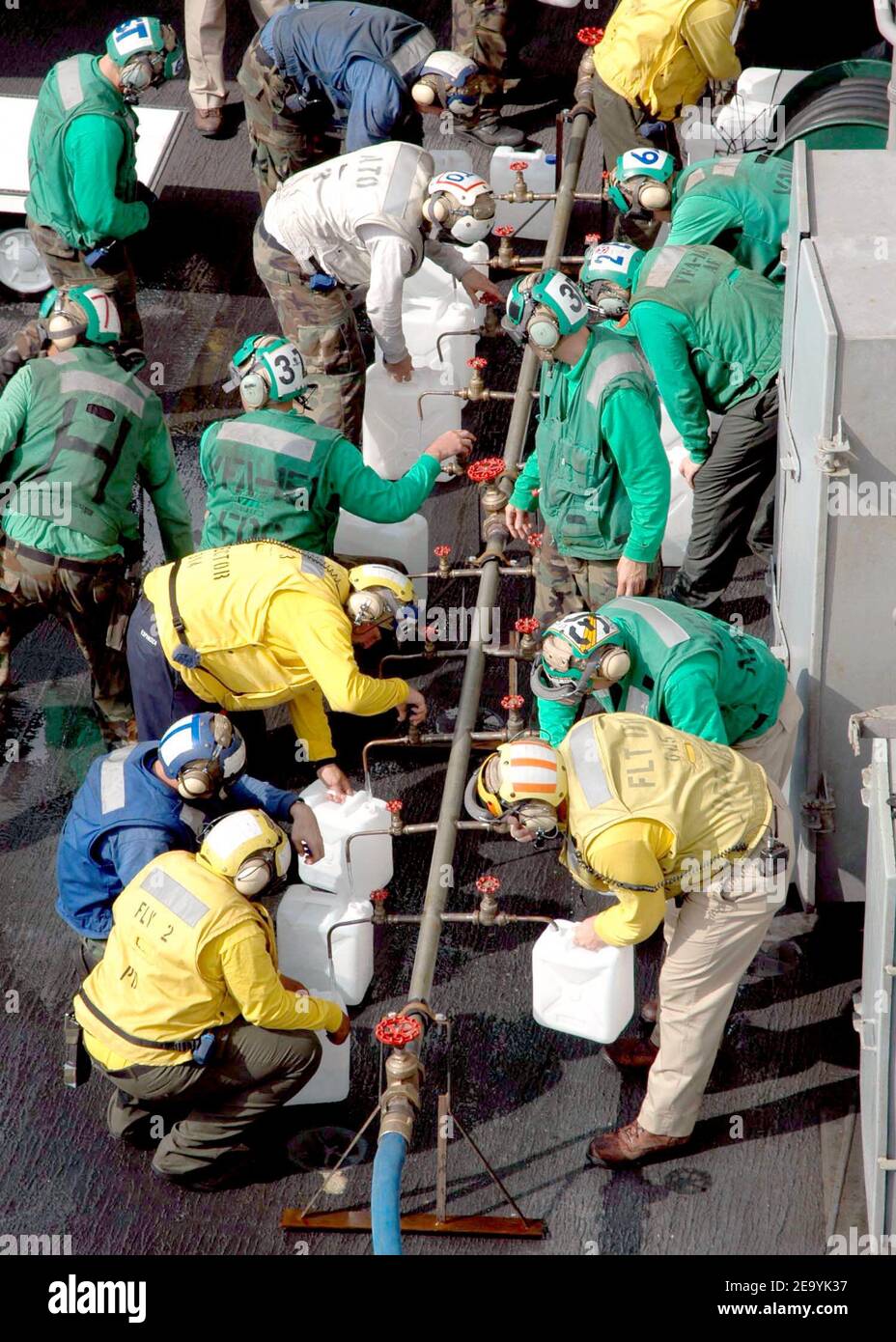 Crew members aboard USS Abraham Lincoln (CVN 72) fill jugs with purified water from a Potable Water Manifold. The Repair Division aboard Lincoln constructed the manifold in eight hours. The water jugs will be flown by Navy helicopters to regions isolated by the Tsunami in Sumatra, Indonesia. Helicopters assigned to Carrier Air Wing Two (CVW-2) and Sailors from Abraham Lincoln are supporting Operation Unified Assistance, the humanitarian operation effort in the wake of the Tsunami that struck South East Asia. Photo by Cristina R. Morrison/USN via ABACA. Stock Photo