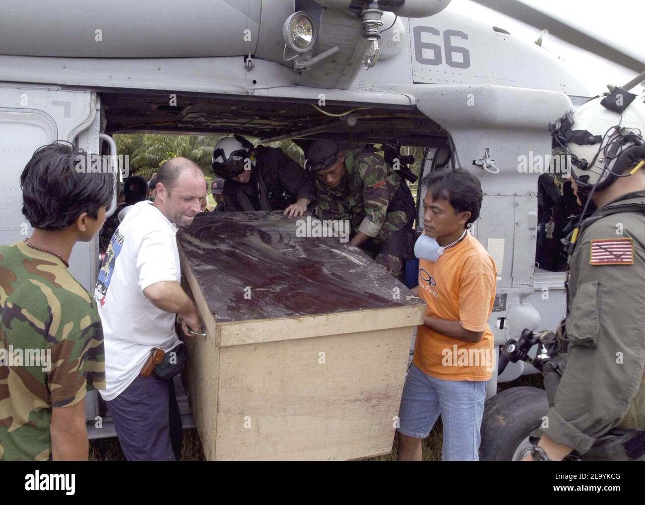 Foreign aid workers and military personnel work together to unload a box of relief supplies from an MH-60S Knighthawk helicopter assigned to the -Gunbearers- of Helicopter Combat Support Squadron Eleven (HC-11). Helicopters assigned to Carrier Air Wing Two (CVW-2) and Sailors from Abraham Lincoln are supporting Operation Unified Assistance, the humanitarian operation effort in the wake of the Tsunami that struck South East Asia. Photo by Patrick M. Bonafede/USN via ABACA Stock Photo