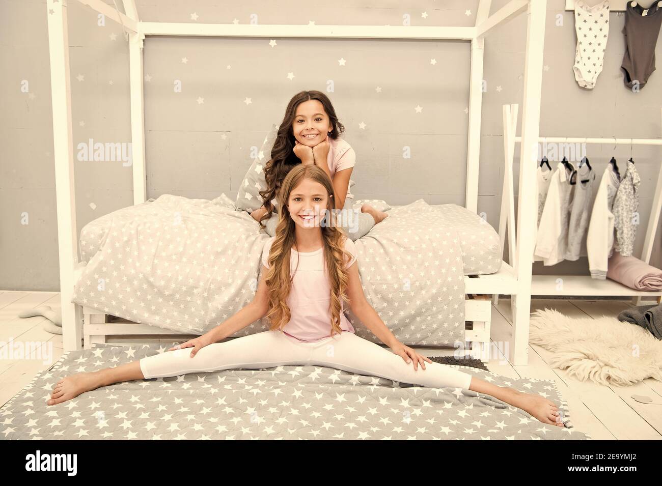 Stay at home. Small girls feel happy at home. Little children play in bedroom. Home clothing. Rest and relaxation. Bedtime routine. Leisure and lounge. Self isolation and quarantine. Lets stay home. Stock Photo