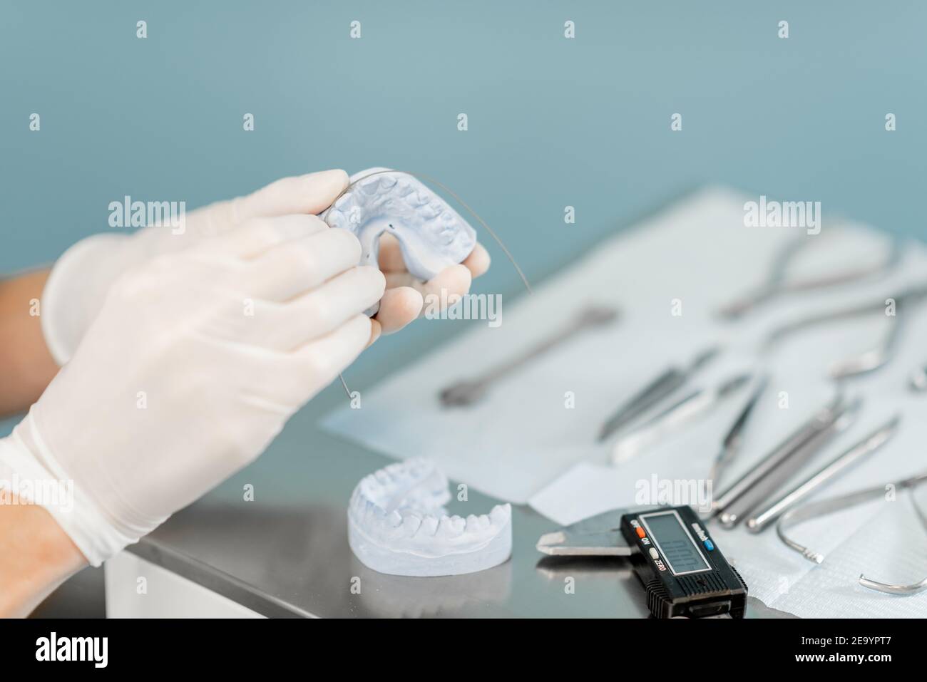 Dental technician working with a model of teeth and dental braces Stock ...