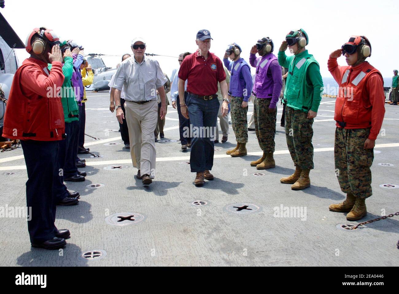 Former Presidents George H.W. Bush, left, and Bill Clinton and walk through -Rainbow Sideboys- as they are piped aboard the amphibious dock landing ship USS Fort McHenry (LSD 43). Sailors and Marines greeted the former Commander-in-Chiefs. Presidents Bush and Clinton are touring Sri Lanka, Thailand and Indonesia to see first hand, the effects the Tsunami had on Southeast Asia on February 20, 2005. Photo David J. Ham/USN via ABACA. Stock Photo