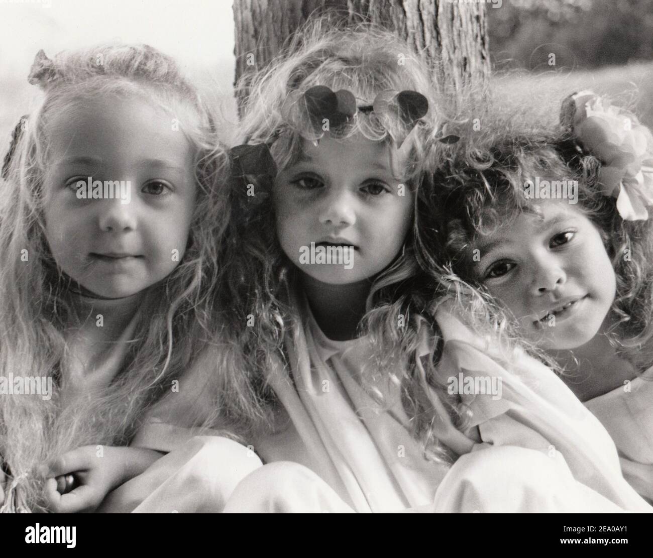 scanned monochrome grainy print of three little girls in the style of Julia Margaret Cameron Stock Photo