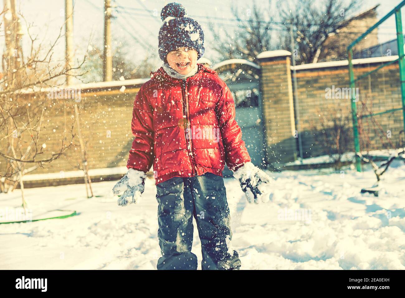 Excited Child playing with snow on white snow background. smiling boy ...