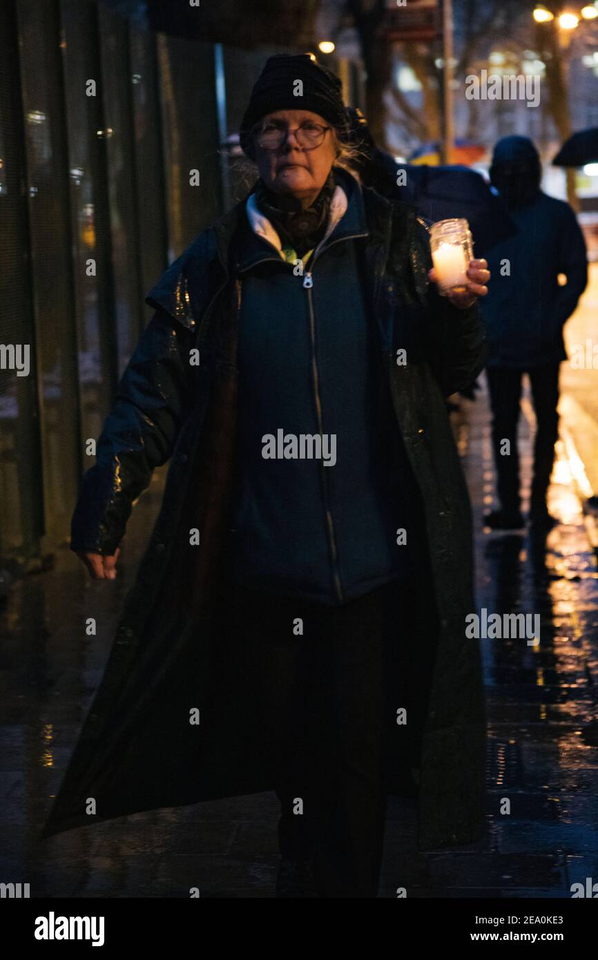 London, UK. 6th February, 2021. Candlelit vigil in remembrence of the lost trees at Euston Square, London as part of the Stop HS2 protest February 6th 2021. A mature woman carries a candle in her hand Credit: Denise Laura Baker/Alamy Live News Stock Photo