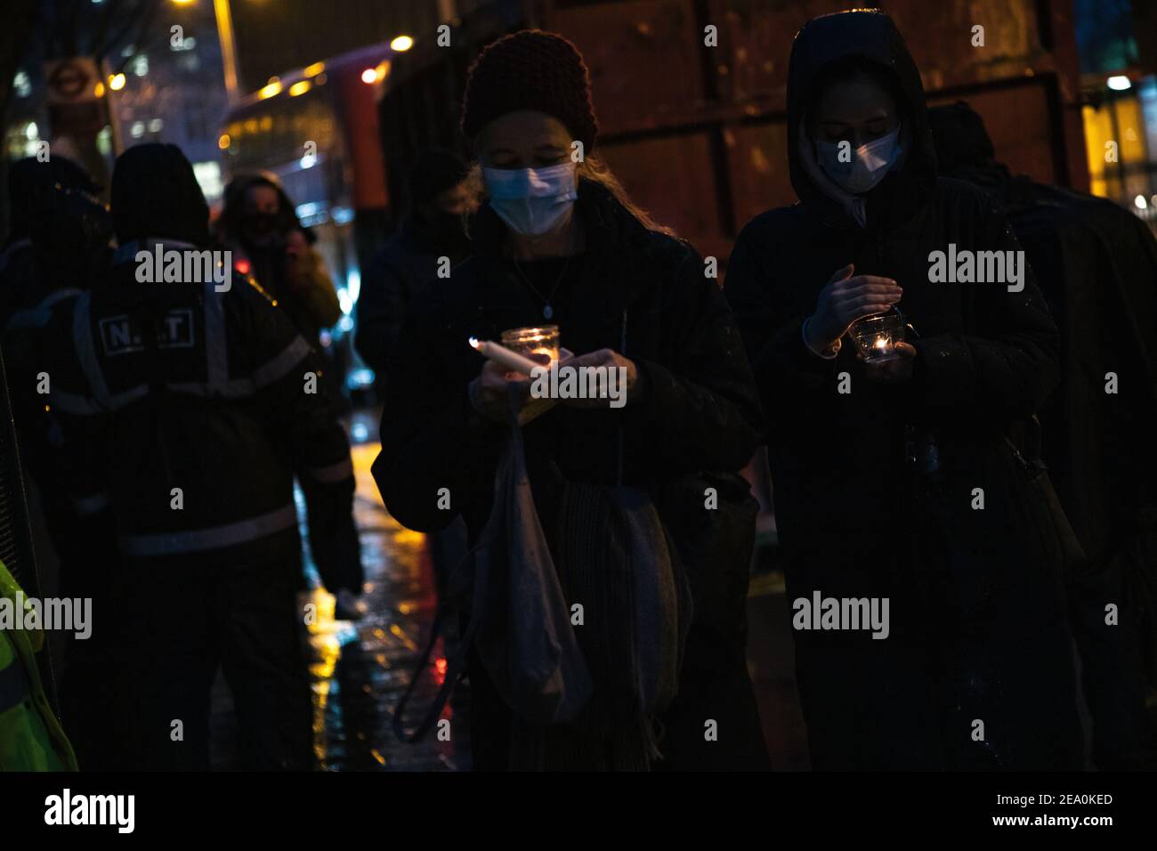 London, UK. 6th February, 2021. Candlelit vigil in remembrence of the lost trees at Euston Square, London as part of the Stop HS2 protest February 6th 2021. Two women carry candles Credit: Denise Laura Baker/Alamy Live News Stock Photo