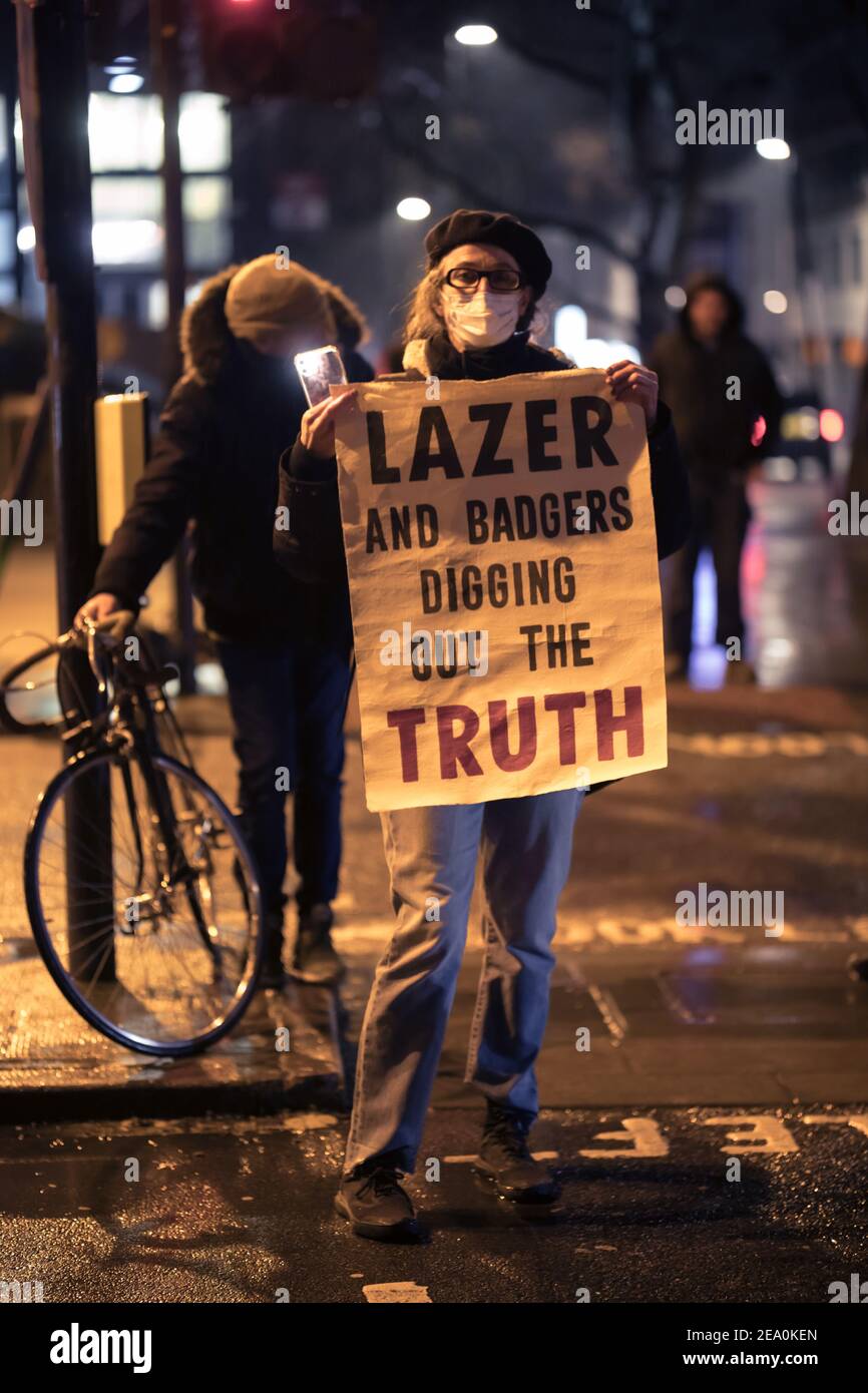 London, UK. 6th February, 2021. Candlelit vigil in remembrence of the lost trees at Euston Square, London as part of the Stop HS2 protest February 6th 2021. A woman holds a poster with the name Lazer on it in support of one of the young tunnellers. Credit: Denise Laura Baker/Alamy Live News Stock Photo