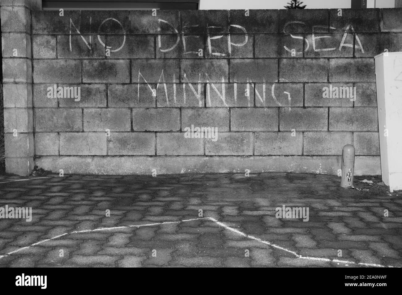 Anti deep water mining misspelt message in chalk on concrete block wall Stock Photo