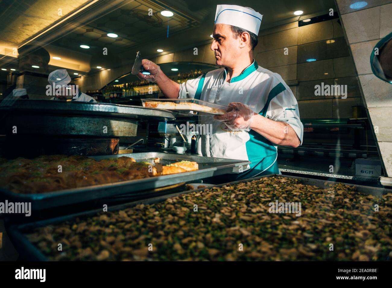 A pastry chef baking trays of traditional Lebanese sweets in Beirut, Lebanon Stock Photo